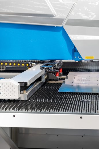 2 CNC punching machine processing metal sheet in automated industrial manufacturing facility for precision metal fabrication and production CNC punching machine processing a metal sheet in an automated industrial facility, used for precision sheet metal fabrication and high-efficiency manufacturing